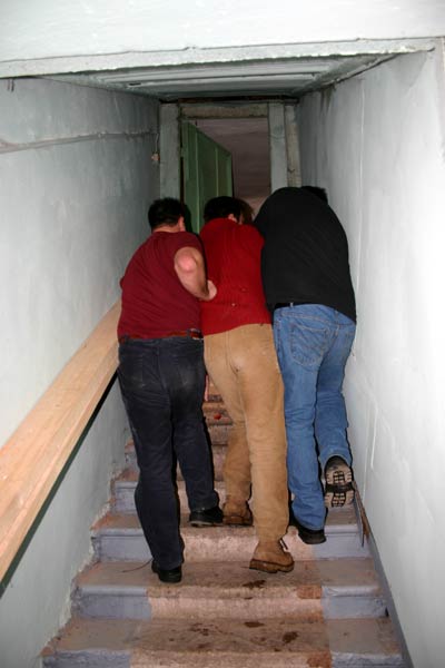 Это не соревнование - кто быстрей протиснется в туалет :) Это тащат тяжелый ящик по узкой лестнице.
